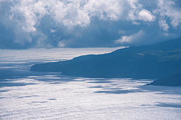 Dark clouds gathering over the rugged Atlantic cliffs along the western coastline of Flores Island, Azores, Portugal.