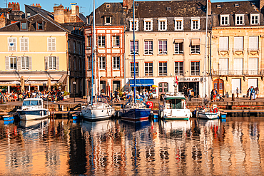 Waterfront houses and moored sailing boats at the historic Vieux Bassin harbor, Honfleur, Normandy, France.
