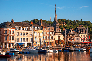 View of the harbor with the wooden bell tower of Sainte-Catherine’s Church rising in the background, Honfleur, Normandy, France.