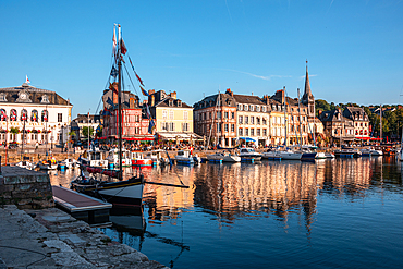 Boats moored in the Vieux Bassin with traditional slate-fronted houses reflected in the water, Honfleur, Normandy, France.