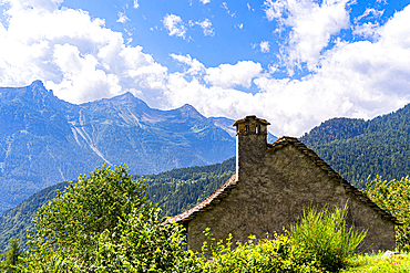 A traditional rural architecture style house built of rocks from the mountain in a beautiful alpine valley in summer, Piemonte (Piedmont), Northern Italy, Europe