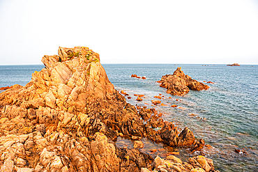Golden light on rugged coastal rocks at Lions Rock, Guernsey, Channel Islands — dramatic shoreline overlooking the Atlantic Ocean