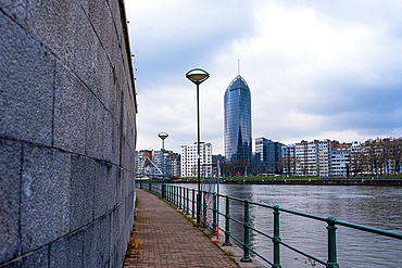 Path along the River Maas, looking along the walkway to La Tour des Finances de Leige (Tour Paradis), Liege, Belgium, Europe