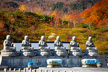 Row of six shizo statues with a beautiful autumnal landscape in the background, Osorezan Bodaiji Temple, Mutsu, Aomori prefecture, Honshu, Japan, Asia