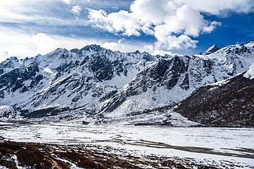 View over the snowy glacial plain of high altitude winter valley on the Langtang trek in Kyanjin Gompa, Himalayas, Nepal, Asia