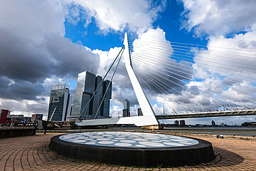 Impressive Erasmus bridge in Rotterdam harbor with dramatic sky and art in the foreground, Rotterdam, The Netherlands, Europe