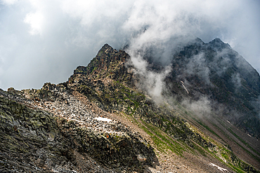 view a long the rugged mountain pass of Colle del Turlo in North Italy. Clouds and steep slopes