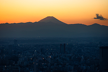 Orange sunset skyline of Tokyo with the silhouette of snowy Fuji San Mountain, Tokyo, Honshu, Japan, Asia