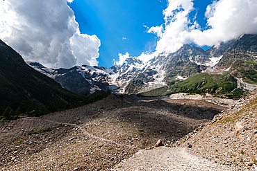 Hiking trail in alpine landscape facing Monte Rosa. Moraine landscape in the Alps of North Italy