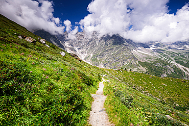 Hiking trail in alpine landscape facing Monte Rosa. Moraine landscape in the Alps of North Italy