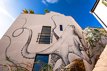 Kraken Street art on white walls, Gibraltar Castle Steps, beautiful residential area on the hill of narrow alleys, Gibraltar, Europe