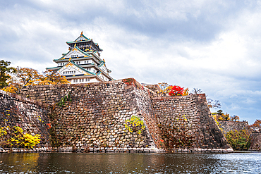 Osaka Castle walls and moat with autumnal foliage, traditional Samurai Castle of Osaka, Honshu, Japan, Asia