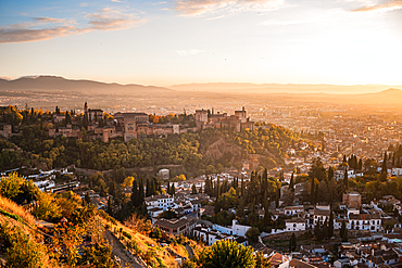 Hazy orange red sunset over Granada viewed from San Miguel Alto over the Alhambra and Albaicin, Granada, Andalusia, Spain, Europe