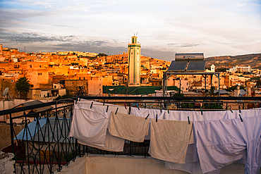 Sunrise in Fes, drying white cloths on a clothing line. Medina old town with Kairaouine Mosquein the background. Morocco, Fes