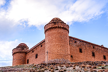 Castillo de La Calahorra, Guadix, Spain. red castle walls against a blue sky