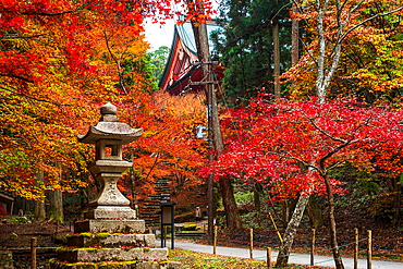 Stone lantern at Mount Hiei, Hiei San. Close up of Autumnal foliage and red shinto temple wooden structure. Beautiful Japanese Shinto Pagod in an autumnal forest on the sacred mount Hiei. Hieizan Enryaku-ji Temple Yokawa