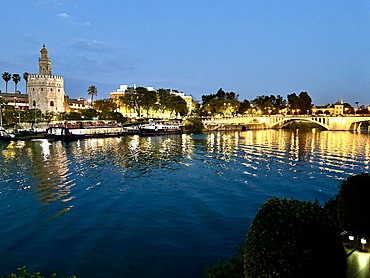 Sunset view of the Guadalquivir River in Seville, Spain with the Torre del Oro (Tower of Gold), a dodecagonal military watchtower erected by the Almohad Caliphate in order to control access to Seville via the river on the left.