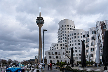 View of the Neuer Zollhof (The New Zollhof), named after a former customs facility, a prominent landmark of Dusseldorf-Hafen, part of the redeveloped port of Dusseldorf,  with the Rheinturm (Rhine Tower) telecommunications tower in the background, Dusseldorf, North Rhine Westphalia, Germany, Europe