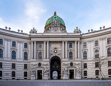 Vienna, Austria – View of St. Michael's Wing at Michaelerplatz, the grand Baroque facade of Hofburg Palace's entrance with its monumental dome and sculpted imperial eagles overlooking the square.