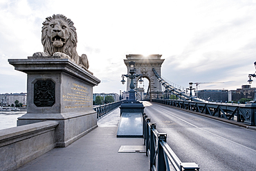 Budapest, Hungary – View of one of the stone lions guarding the entrance to the Chain Bridge, a 19th-century suspension bridge linking Buda and Pest across the Danube River.