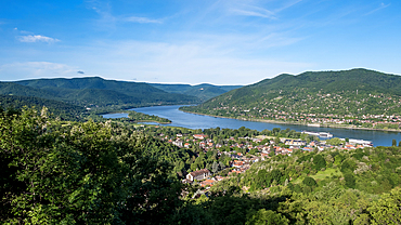 Visegrád, Hungary – View of the Danube Bend from the castle town of Visegrád (Vyšehrad), with red-roofed houses nestled in forested hills below the medieval citadel and royal palace ruins.