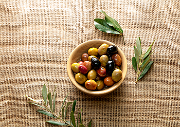 Olives in olive oil in a small bowl, with leaves, on a canvas, Istanbul, Turkey, Europe