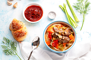 Uzbek food with meat and noodle, Lagman, on table with spices and greenery, Tashkent, Uzbekistan, Central Asia, Asia