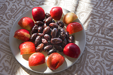 Fruit plate (dates and apple) served aboard the Dahabeah,passenger river boat of the Lazuli fleet, sailing on the Nile river, Egypt, northeast Africa