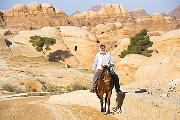 Man riding a horse along the access track to the gorge of Petra, UNESCO World Heritage Site, Jordan, Middle East