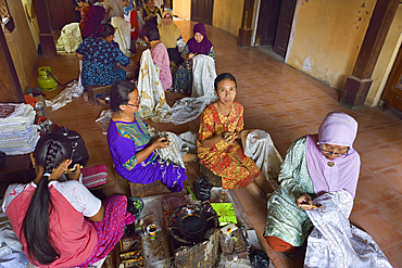 Women using a pen-like tool (canting) to apply liquid hot wax in the batik-making process, Wirakuto batik workshop, Pekalongan, Java island, Indonesia, Southeast Asia, Asia