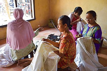 Women using a pen-like tool (canting) to apply liquid hot wax in the batik-making process, Wirakuto batik workshop, Pekalongan, Java island, Indonesia, Southeast Asia, Asia