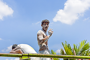 man unloading sacks of flour off a truck on the road from Semarang to Juwana, Java island, Indonesia, Southeast Asia