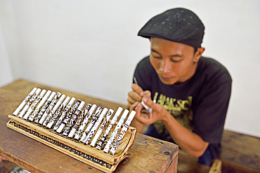 Man painting batik pattern with coffee grounds on cigarettes, Tapel Koeda Kretek (Clove Cigarette) Factory at Juwana, Java island, Indonesia, Southeast Asia, Asia