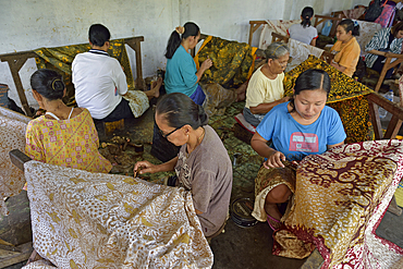 women using a pen-like tool, called 'canting', to apply liquid hot wax to create pattern on the fabric before dyeing, workshop of Kidang Mas Batik House, Lasem, Java island, Indonesia, Southeast Asia