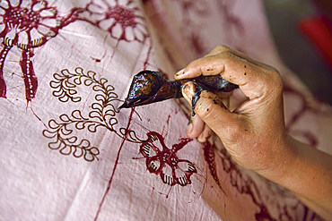 Woman using a pen-like tool (canting) to apply liquid hot wax to create pattern on the fabric before dyeing, workshop of Kidang Mas Batik House, Lasem, Java island, Indonesia, Southeast Asia, Asia