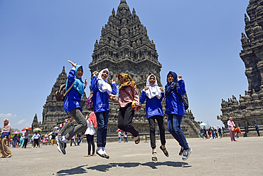 Students with teacher in coloured scarf in centre taking a dynamic pose during an educational school trip at Prambanan Temple Compounds, UNESCO World Heritage Site,  region of Yogyakarta, Java island, Indonesia, Southeast Asia, Asia