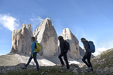 three hikers walking at the foot of the Tre Cime di Lavaredo (Three Peaks of Lavaredo), Three Peaks nature park, Trentino-Alto Adige, Sudtyrol, South Tyrol, Italy, South-central Europe