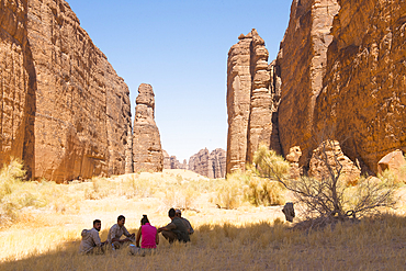 Sitting people meeting in front the magnificent sandstone rock structure in the Sharaan Nature Reserve, AlUla, Medina Province, Saudi Arabia, Middle East