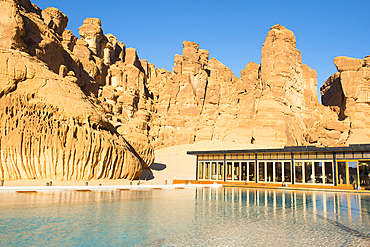 Swimming pool, surrended by magnificent sandstone rock structures, of Our Habitas AlUla, a sustainable desert luxury resort nestled within an ancient oasis in the desert canyons of the Ashar Valley, Medina Province, Saudi Arabia, Middle East