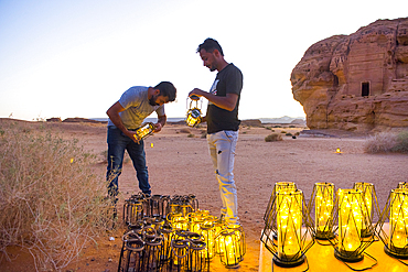 Employees lighting hundreds of lanterns that are scattered around the site for night tours of the UNESCO World Heritage Site of Hegra, AlUla, Medina Province, Saudi Arabia, Middle East