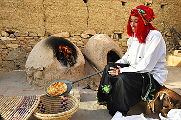 Woman cooking bread in a traditional Berber oven, Atlas Kasbah, guesthouse, near Agadir,Morocco,North Africa