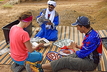 Preparation of the lunch of a group of bike hikers near the dunes of Tindouf, Draa River valley, Province of Zagora, Region Draa-Tafilalet, Morocco, North West Africa