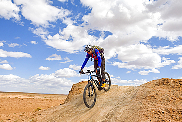 Rider on mountain bike with electric assistance on a track between Ouarzazate and Ait Ben Haddou, Ounila River valley, Ouarzazate Province, region of Draa-Tafilalet, Morocco, North West Africa