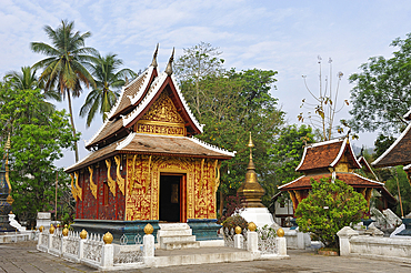 The Red Chapel (Haw Tai Pha Sai-Nyaat), or the Chapel of the Reclining Buddha is covered with a red stucco inlaid with brightly colored glass mosaics that illustrate both religious activities and everyday Lao life, Buddhist temple Wat Xieng Thong, Luang