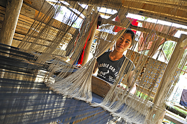 Young woman weaving in a village where live people from both Khmu and Hmong minority ethnics groups, in mountain massif near Nong Khiaw, Luang Prabang Province, Laos, Southeast Asia