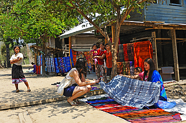 Villagers showing clothes and local crafts for sale to tourists passing through Ban Baw, a traditional Lao Loum village by the Mekong River, between Luang Prabang and Pakbeng, Laos, Southeast Asia