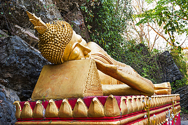 Lying Buddha statue on the path to the stupa of Wat Chom Si on the summit of Mount Phu Si, Luang Prabang, northern Laos, Southeast Asia