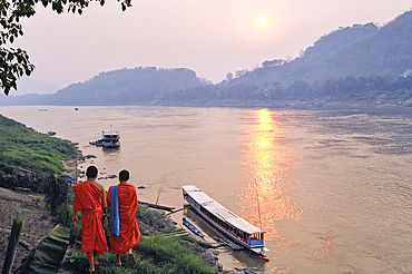 Monks at sunset on Mekong River at Luang Prabang, Laos, Southeast Asia