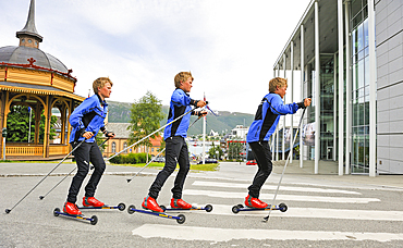 August, young sportsman practising roller ski (photomontage).Tromso.County of Troms,Norway,Northern Europe