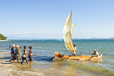 Women at fisherman's return, beach of Ambatoloaka, Nosy Be island,Republic of Madagascar,Indian Ocean